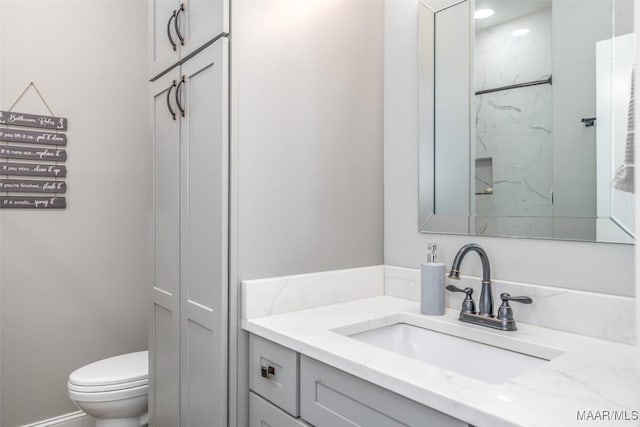 bathroom featuring vanity, toilet, and walk in shower