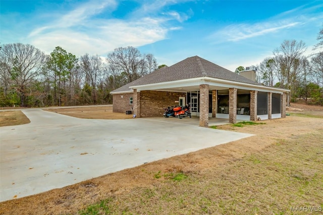 rear view of house featuring a lawn and a sunroom