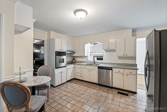 kitchen featuring sink, crown molding, white cabinetry, black appliances, and decorative backsplash