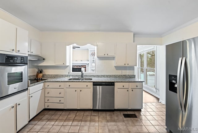 kitchen featuring sink, crown molding, appliances with stainless steel finishes, white cabinetry, and backsplash