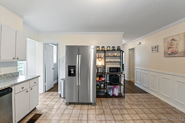 kitchen with white cabinetry, appliances with stainless steel finishes, crown molding, and light stone countertops