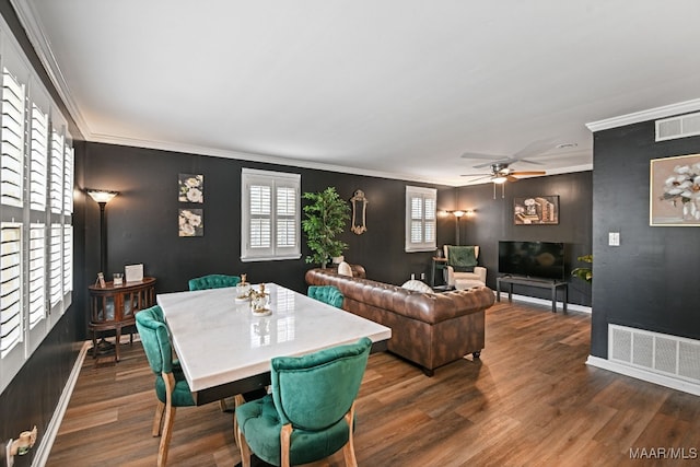 dining space with ornamental molding and dark hardwood / wood-style flooring