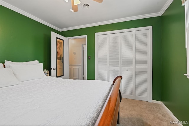 carpeted bedroom with crown molding, a closet, and ceiling fan