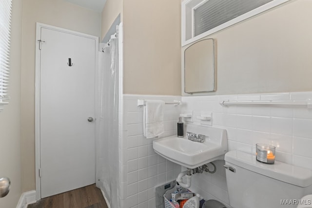 bathroom featuring tile walls, sink, hardwood / wood-style floors, and toilet