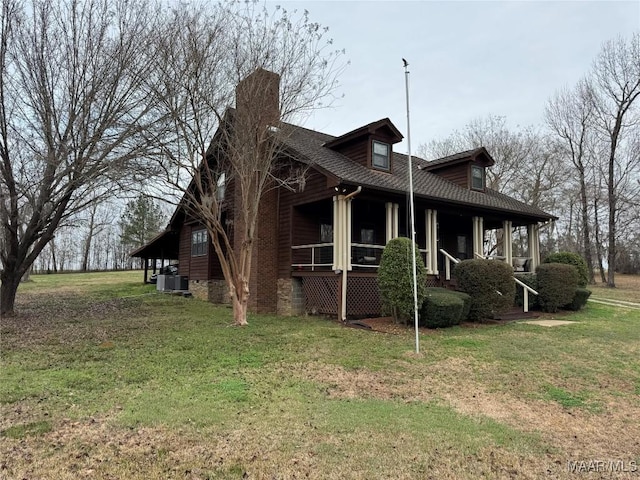 view of side of property featuring cooling unit, a lawn, and covered porch