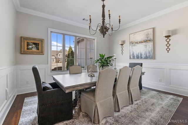 dining space featuring an inviting chandelier, ornamental molding, and dark hardwood / wood-style floors