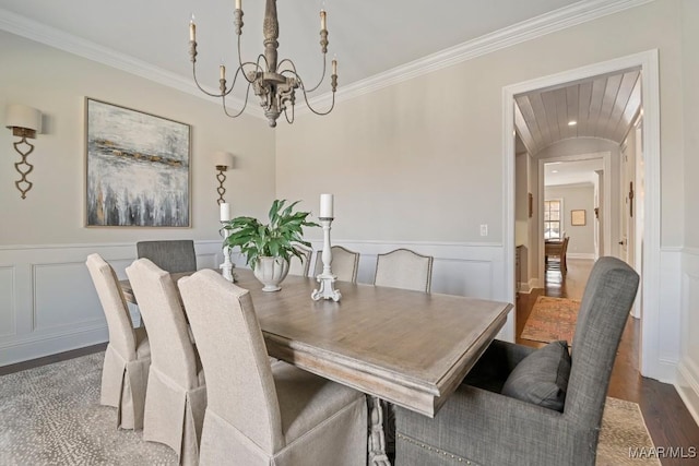 dining area featuring an inviting chandelier, ornamental molding, and dark hardwood / wood-style floors