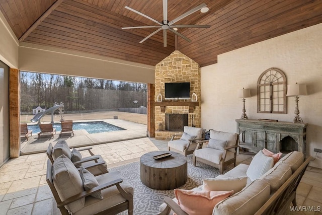 view of patio / terrace featuring an outdoor living space with a fireplace, pool water feature, and ceiling fan