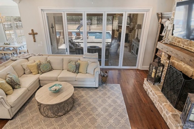 living room with dark hardwood / wood-style floors, a healthy amount of sunlight, and a fireplace