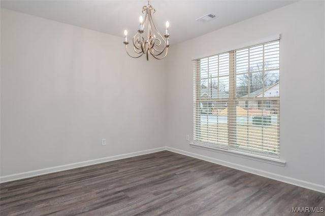 unfurnished room featuring dark hardwood / wood-style flooring and a notable chandelier