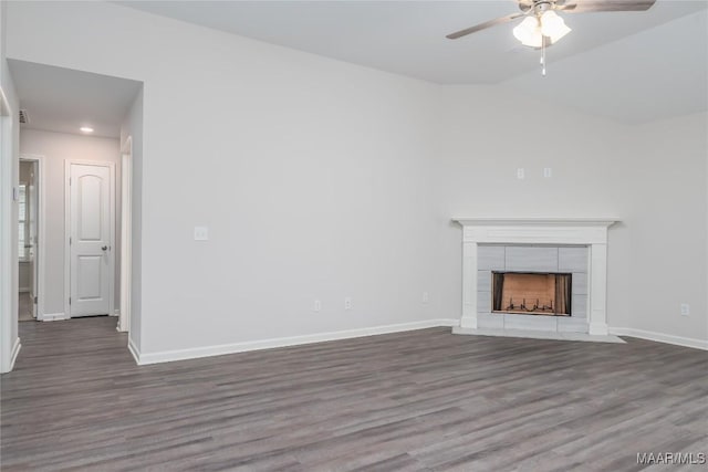 unfurnished living room featuring hardwood / wood-style flooring, a tile fireplace, lofted ceiling, and ceiling fan