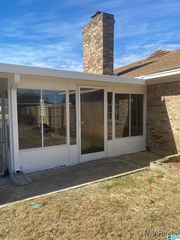 rear view of house featuring a sunroom