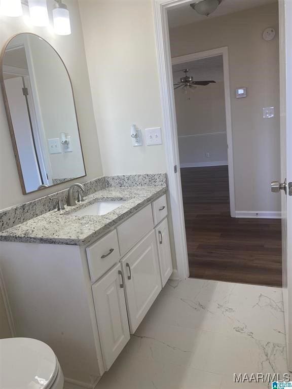 bathroom with vanity, hardwood / wood-style floors, ceiling fan, and toilet