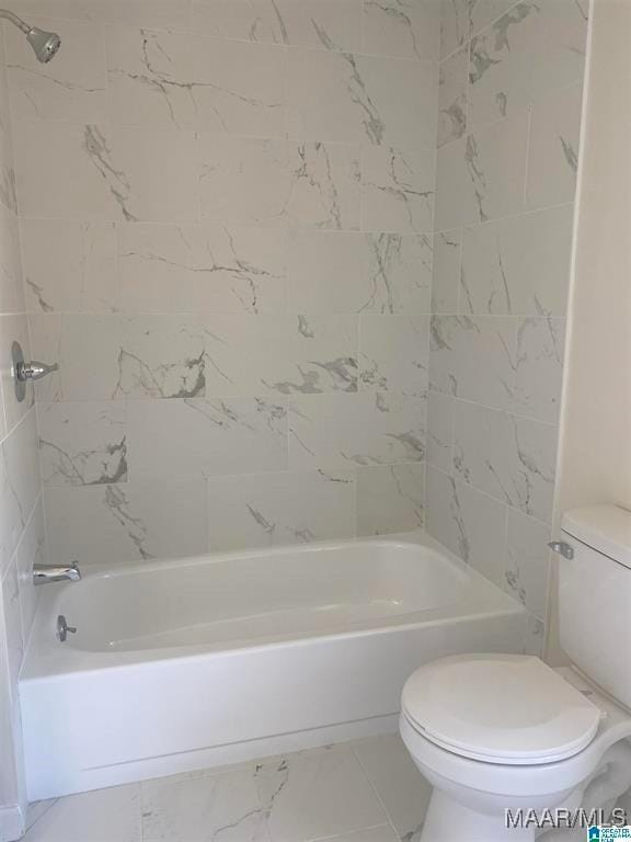 bathroom with tiled shower / bath combo and toilet