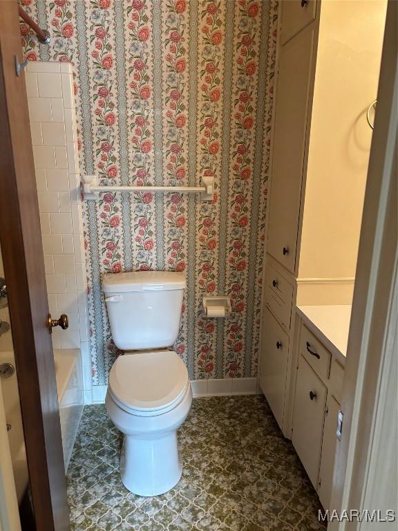 bathroom featuring vanity, a washtub, and toilet