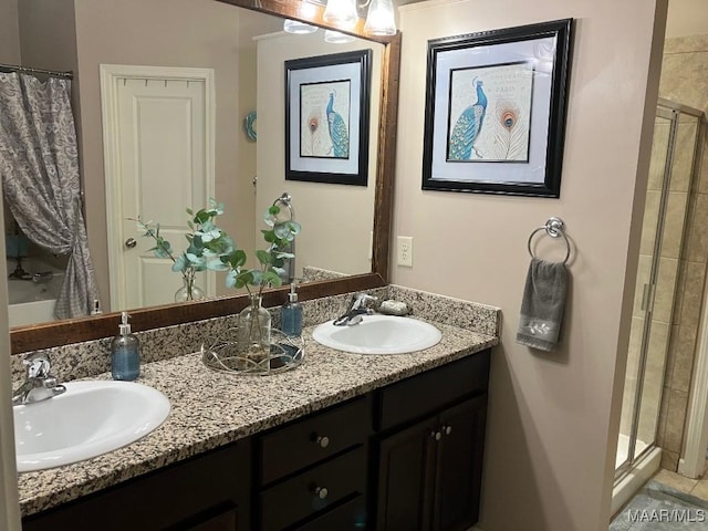 full bathroom featuring a stall shower, a sink, and double vanity