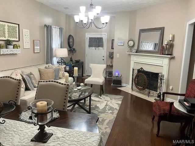 living room featuring a fireplace with flush hearth, baseboards, wood finished floors, and an inviting chandelier