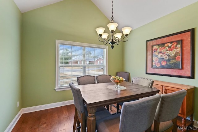 dining space with lofted ceiling, dark wood-type flooring, and an inviting chandelier