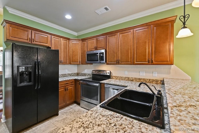 kitchen with light stone counters, sink, stainless steel appliances, and hanging light fixtures