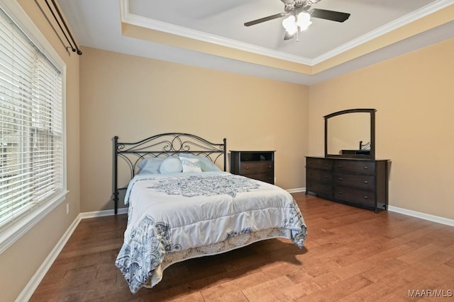 bedroom featuring crown molding, a tray ceiling, and hardwood / wood-style floors