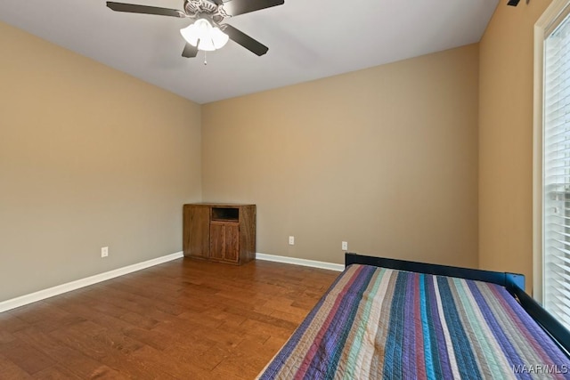 unfurnished bedroom with dark hardwood / wood-style flooring and ceiling fan