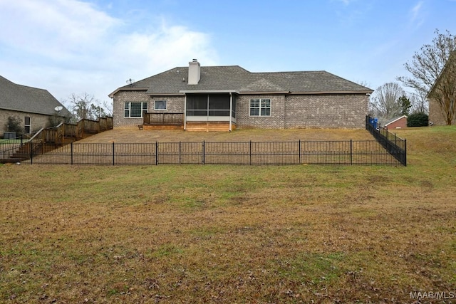 back of house featuring a sunroom and a lawn