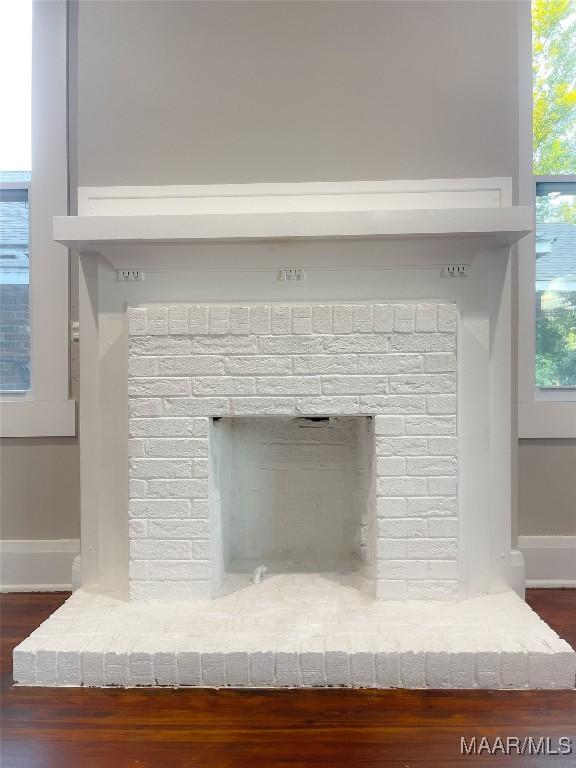 interior details with a brick fireplace and hardwood / wood-style floors