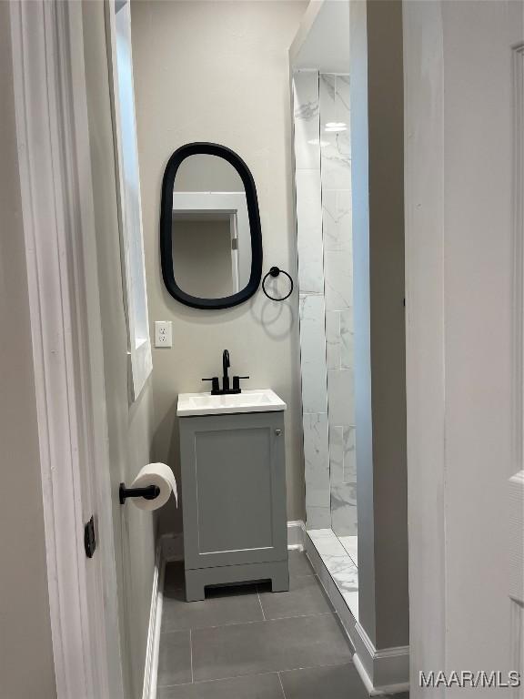 bathroom featuring vanity, tile patterned floors, and tiled shower