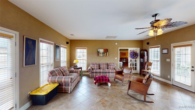 tiled living area featuring a healthy amount of sunlight, visible vents, and baseboards