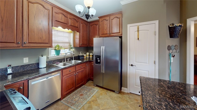 kitchen with an inviting chandelier, appliances with stainless steel finishes, brown cabinetry, a sink, and dark stone counters