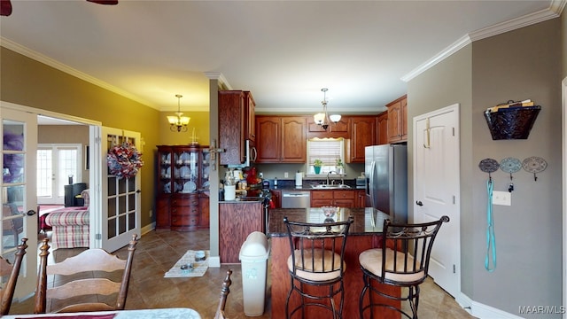 kitchen featuring dark countertops, stainless steel appliances, french doors, a kitchen bar, and a sink