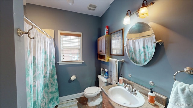 bathroom featuring visible vents, toilet, vanity, baseboards, and tile patterned floors