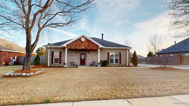 view of front of property featuring a front lawn, fence, and brick siding