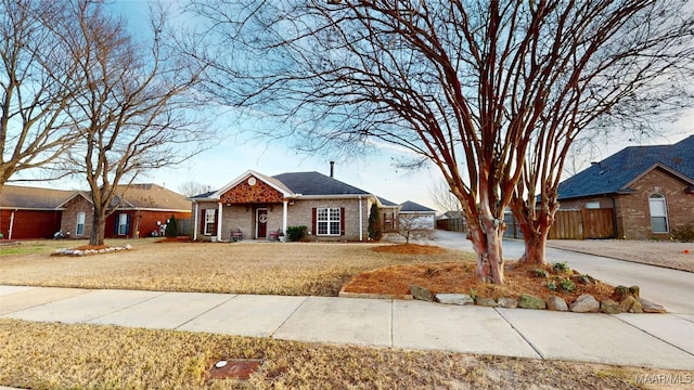 view of front facade featuring fence, a front lawn, and brick siding