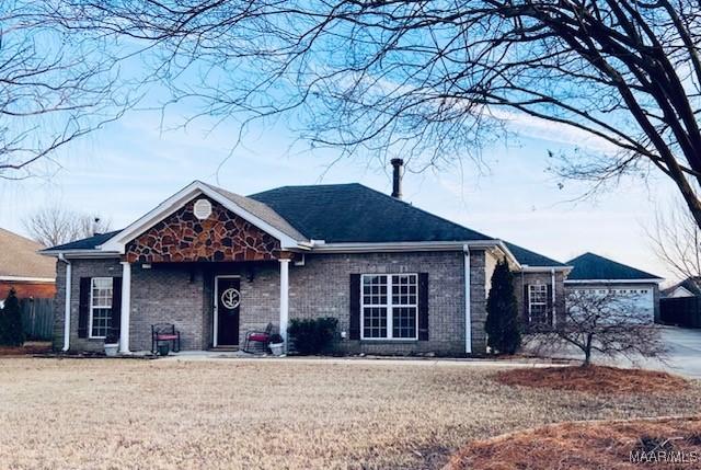 single story home featuring a front yard and brick siding