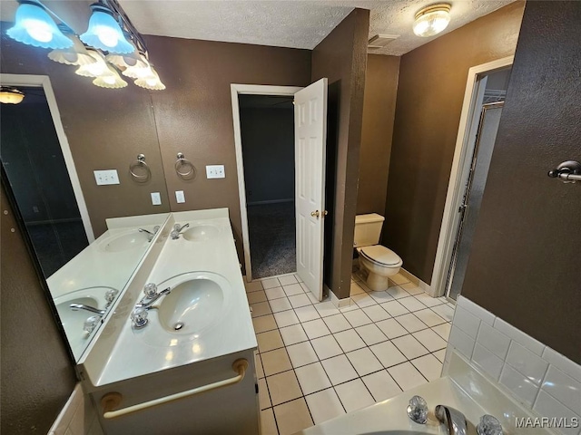 full bath with a textured ceiling, tile patterned flooring, a sink, and toilet