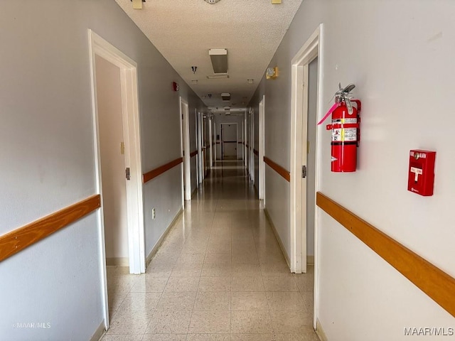 hall featuring a textured ceiling