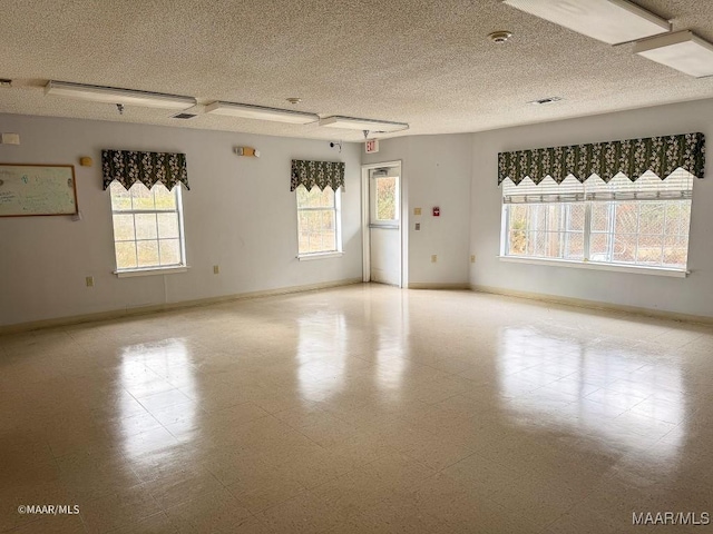 empty room featuring plenty of natural light and a textured ceiling