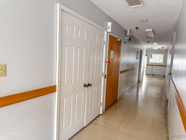 hall with a textured ceiling