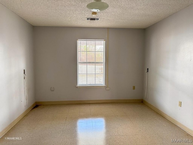 unfurnished room with a textured ceiling