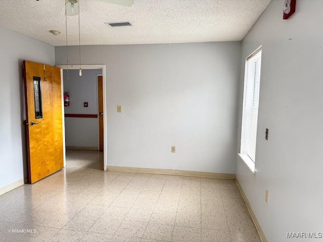 unfurnished room with a textured ceiling