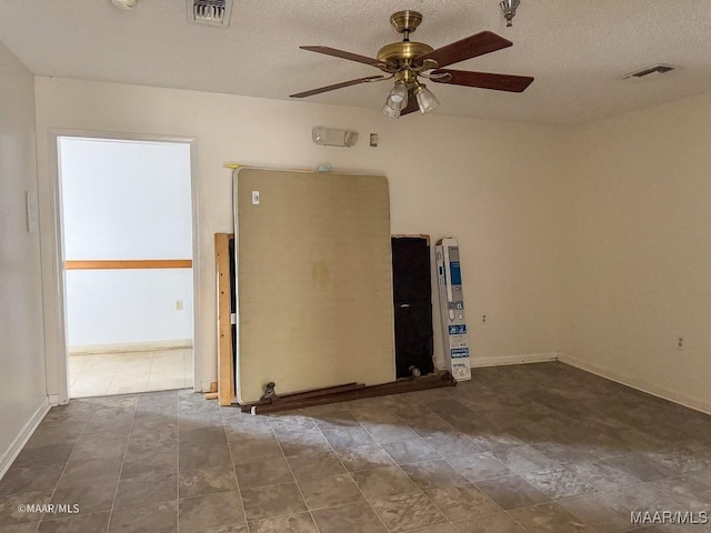 unfurnished room with ceiling fan and a textured ceiling