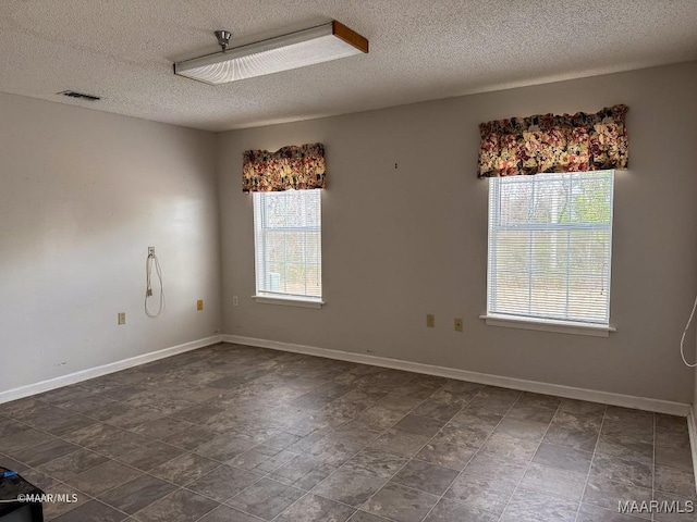 unfurnished room featuring a textured ceiling