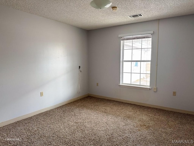 carpeted empty room featuring a textured ceiling