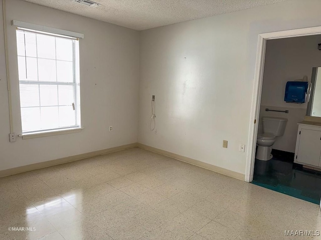 empty room with a healthy amount of sunlight and a textured ceiling