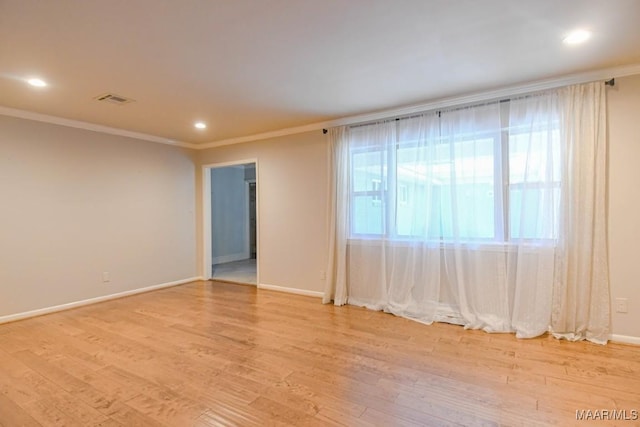 spare room featuring visible vents, baseboards, recessed lighting, crown molding, and light wood-type flooring