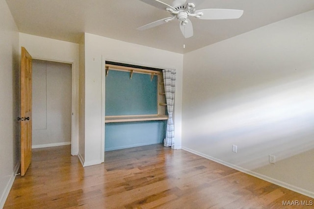 unfurnished bedroom with wood finished floors, baseboards, a closet, and ceiling fan