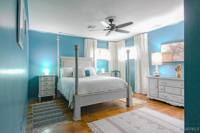 bedroom featuring wood finished floors, visible vents, and ceiling fan