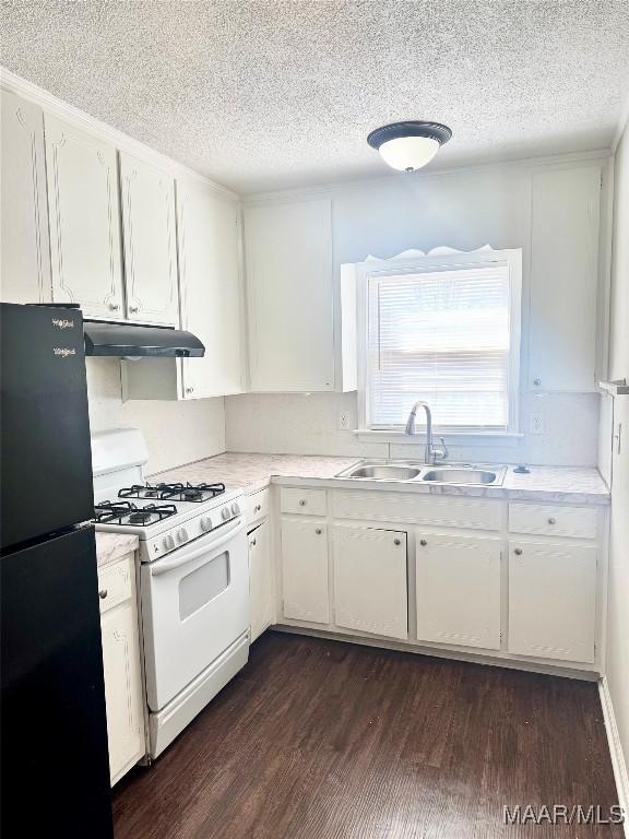 kitchen with dark wood-type flooring, sink, white range with gas stovetop, black refrigerator, and white cabinets