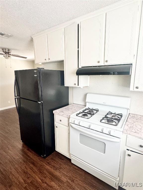 kitchen with gas range gas stove, black refrigerator, white cabinetry, dark hardwood / wood-style floors, and a textured ceiling